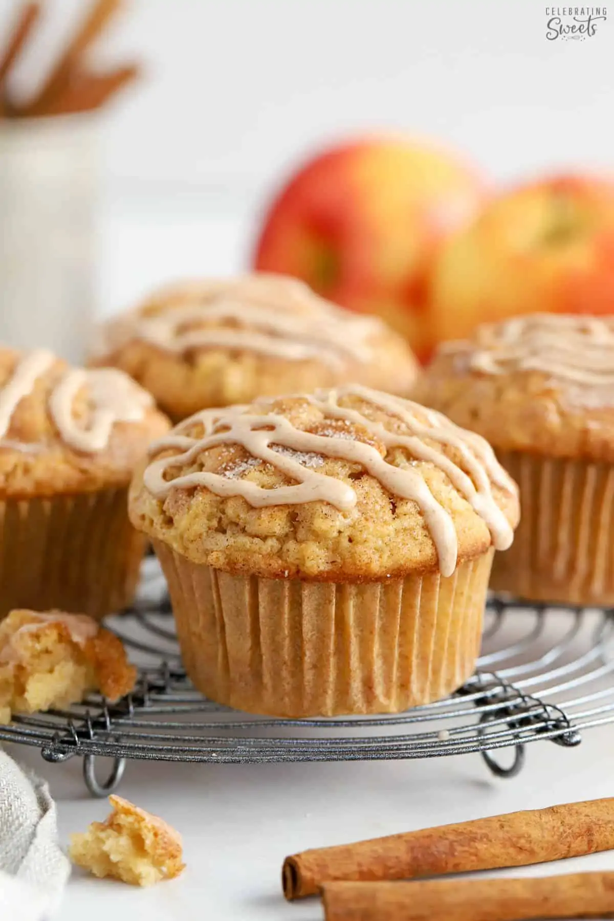 Apple cinnamon muffins on a wire rack topped with a cinnamon icing drizzle.