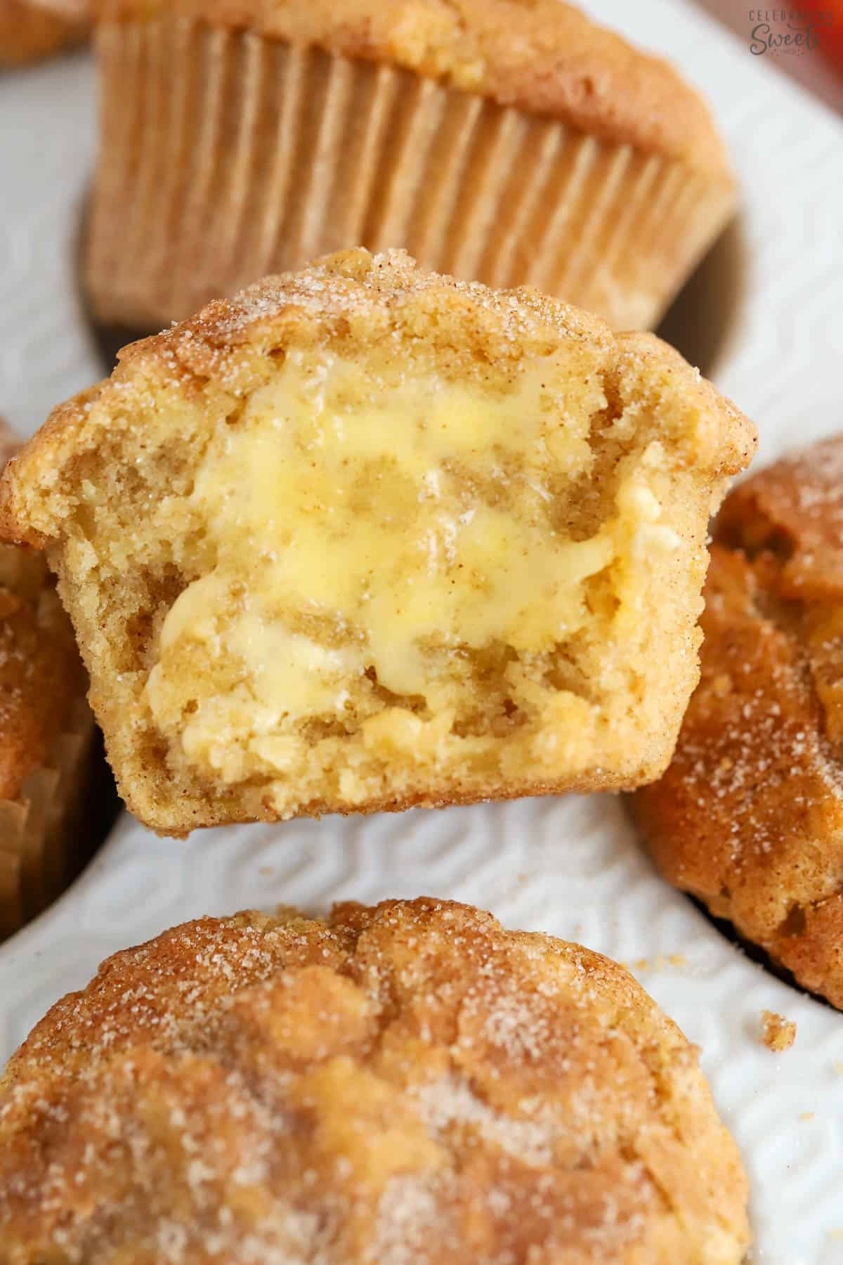 Apple cinnamon muffin cut in half and topped with butter.