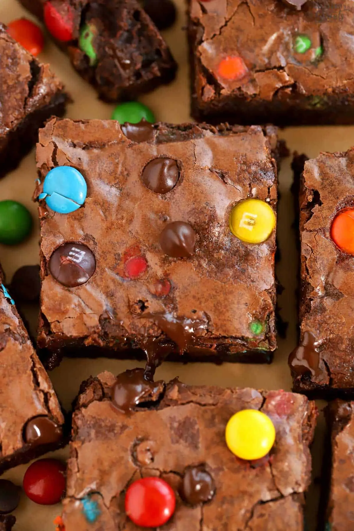 Closeup of M&M Brownies on brown parchment paper.