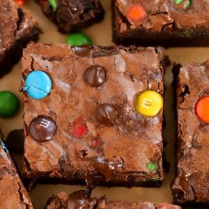 Closeup of M&M Brownies on brown parchment paper.