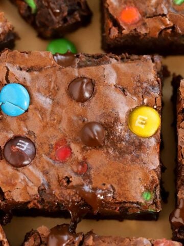 Closeup of M&M Brownies on brown parchment paper.