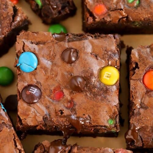 Closeup of M&M Brownies on brown parchment paper.