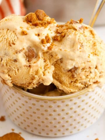 Pumpkin ice cream in a polka dotted bowl with a silver and gold spoon.