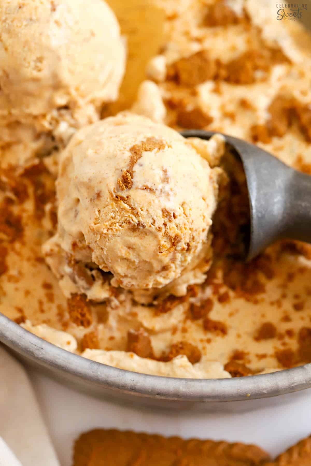 Pumpkin ice cream in a metal pan topped with crushed cookies.