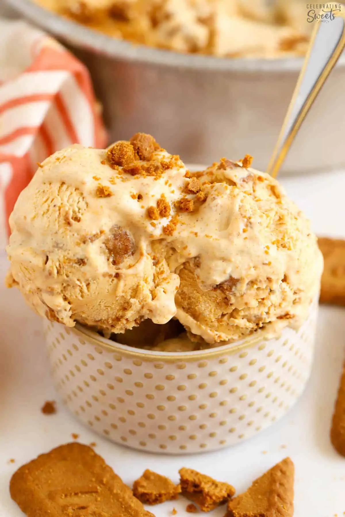 Pumpkin ice cream in a polka dotted bowl with a silver and gold spoon.