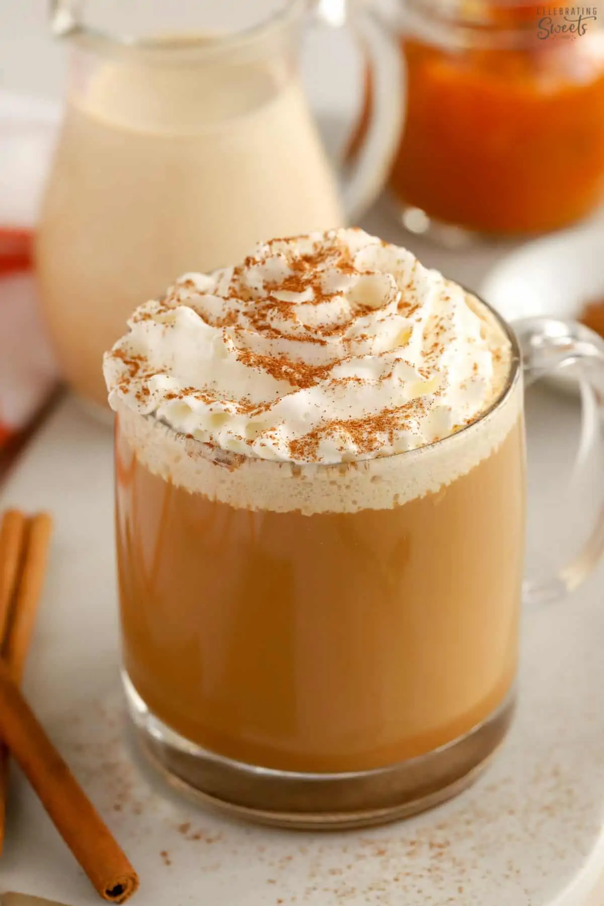 A cup of coffee topped with whipped cream and cinnamon.