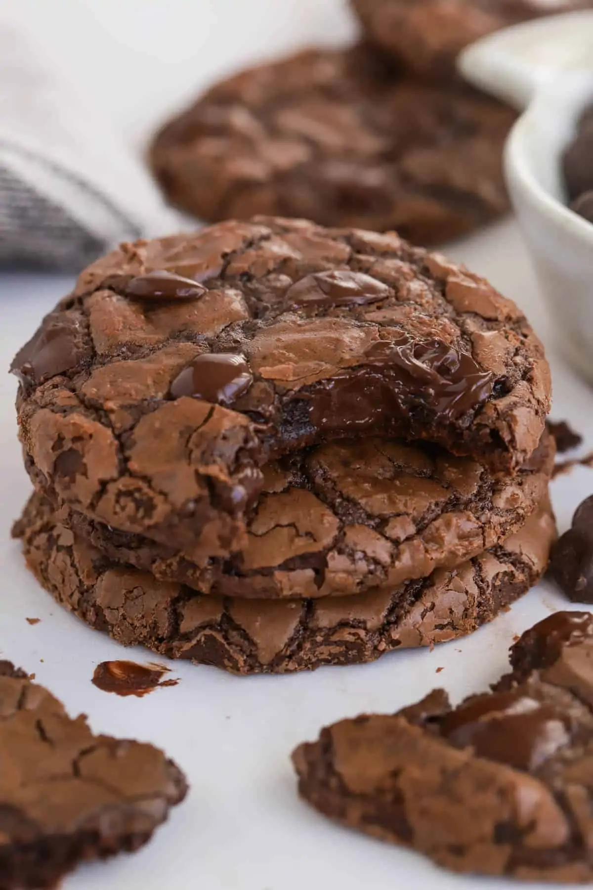 Stack of three brownie cookies with a bite taken out of the top cookie.