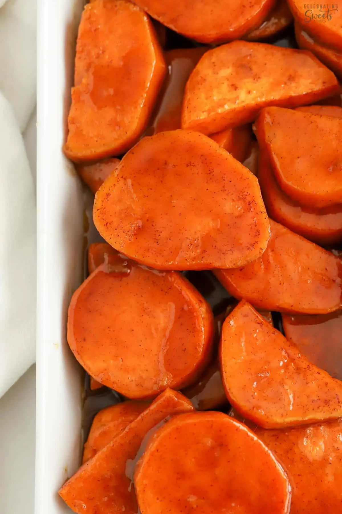 Candied sweet potatoes in a white baking dish.