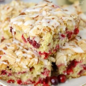 Three slices of cranberry cake stacked on a grey plate.