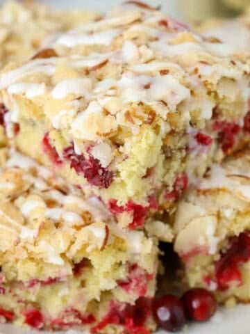 Three slices of cranberry cake stacked on a grey plate.