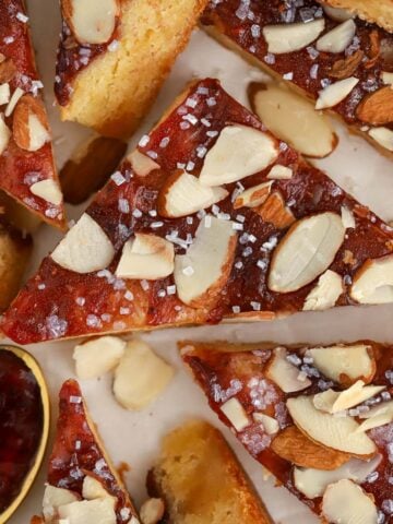 Almond bars cut into triangles on parchment paper.