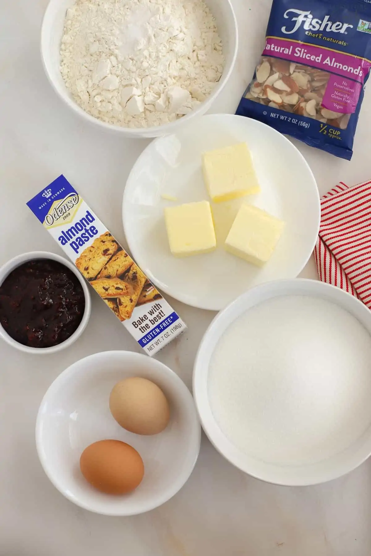 Ingredients for almond bars: eggs, almond paste, sugar, flour, jam, almonds.