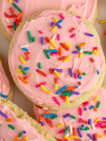 Frosted sugar cookies with pink frosting and colored sprinkles.