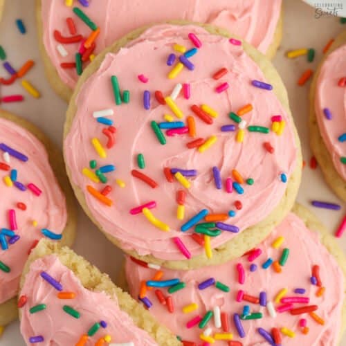Frosted sugar cookies with pink frosting and colored sprinkles.
