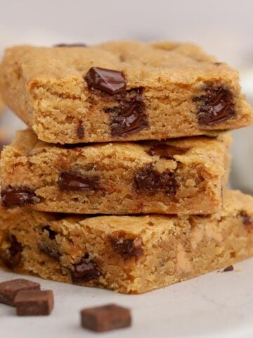 Stack of three chocolate chip blonde brownies.