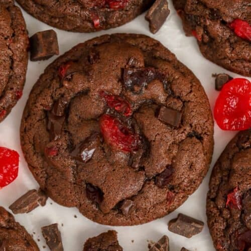Closeup of chocolate cherry cookies on parchment paper.