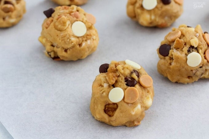 Unbaked kitchen sink cookie dough on a parchment-lined baking sheet.