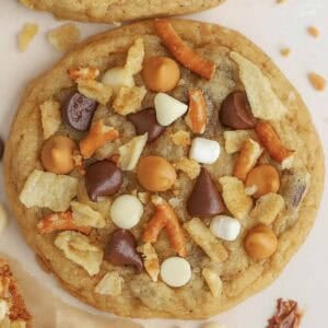 Closeup of a kitchen sink cookie topped with chocolate chips, pretzels, and chips.