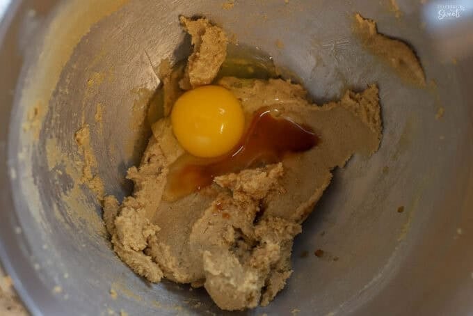 Egg and vanilla in a mixing bowl with cookie dough.