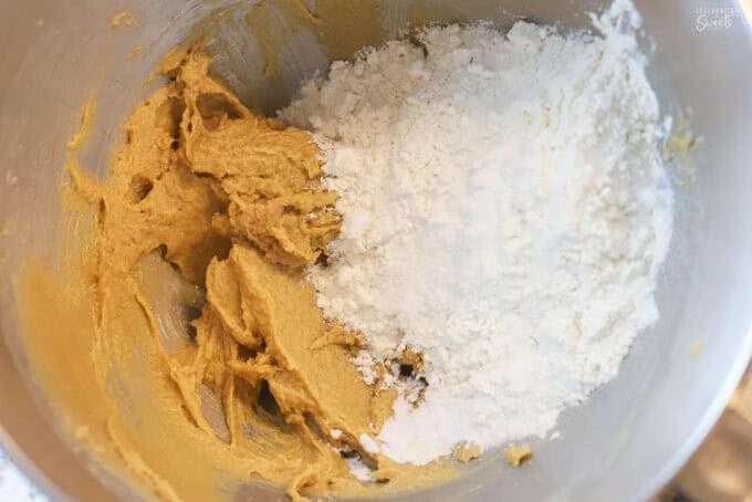 Cookies dough and flour in a large mixing bowl.
