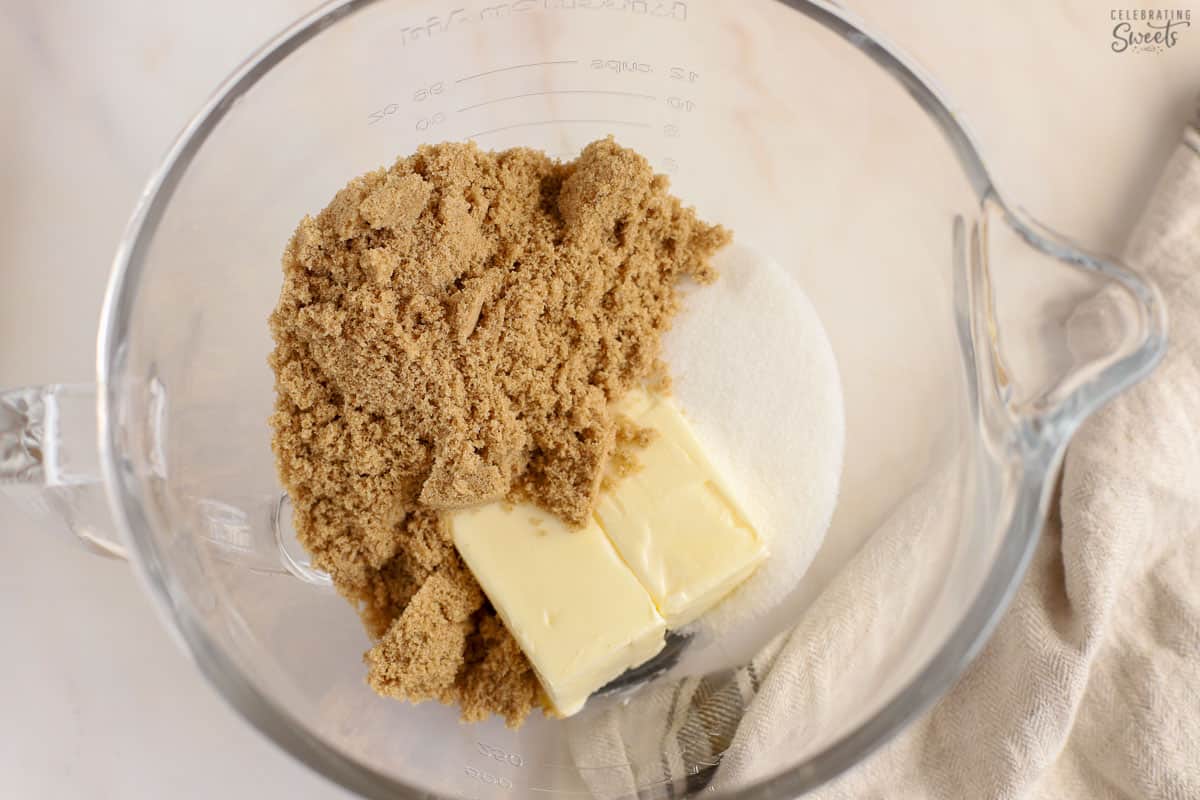 Butter, granulated sugar, and brown sugar in a glass bowl.
