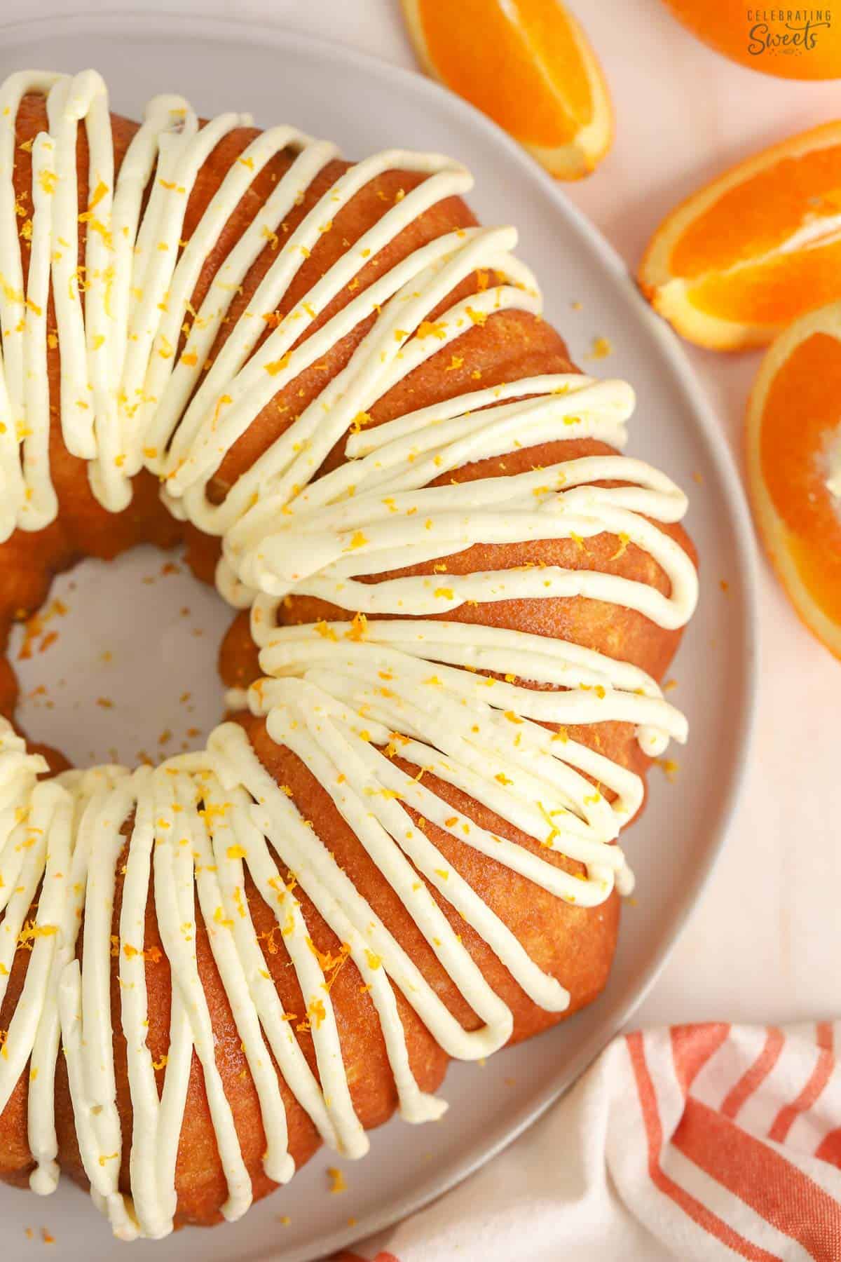 Overhead shot of an orange bundt cake drizzled with white icing.