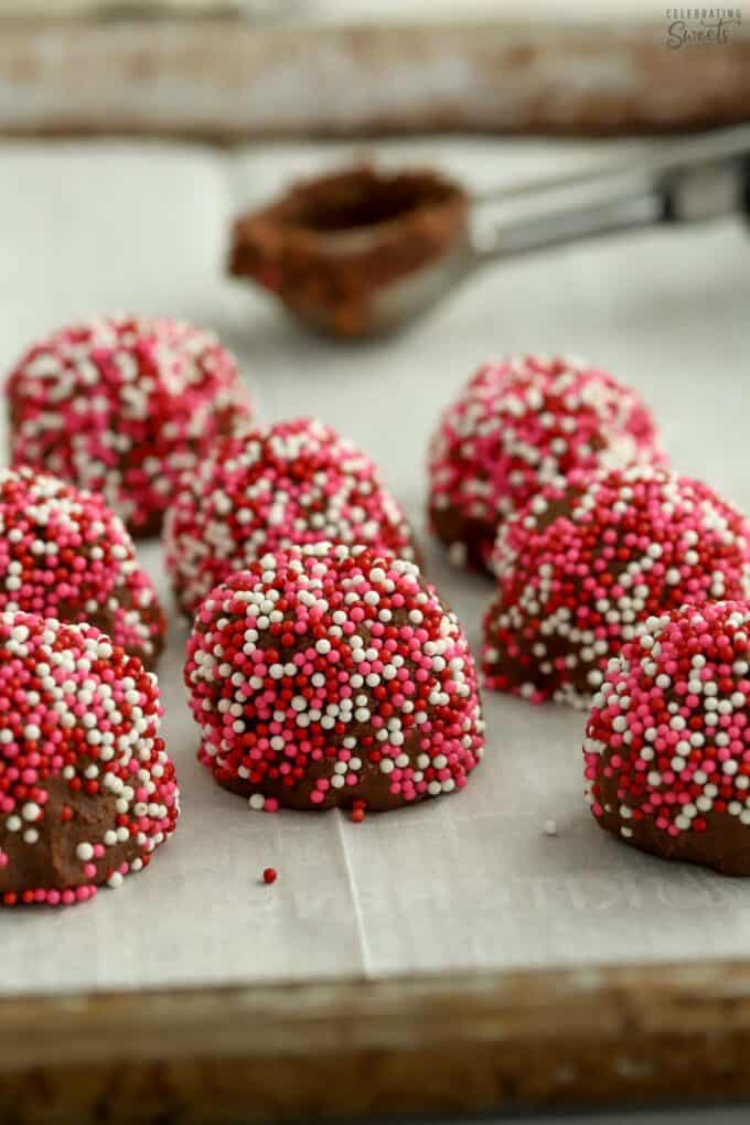 Cookie dough balls rolled in pink and red sprinkles.