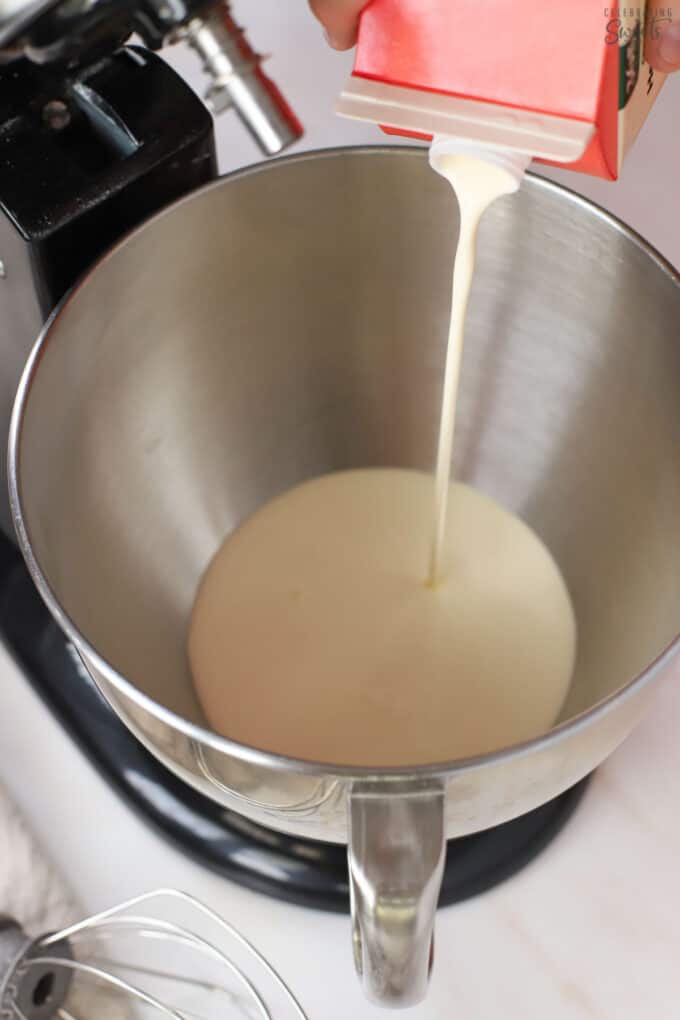 Heavy cream being poured into a mixing bowl.