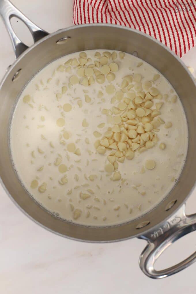 White chocolate chips and heavy cream in a saucepan.
