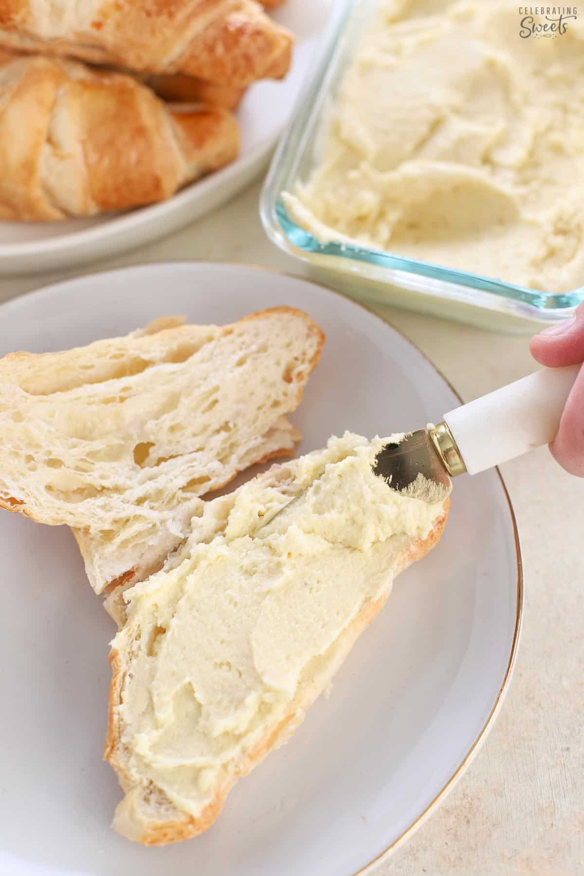 Almond cream being spread on a croissant
