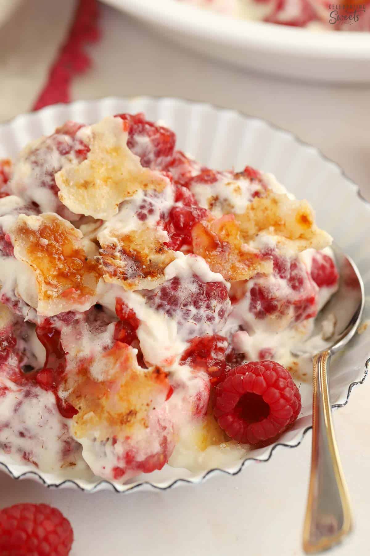 Berries, whipped cream, and caramelized sugar in a white baking dish.