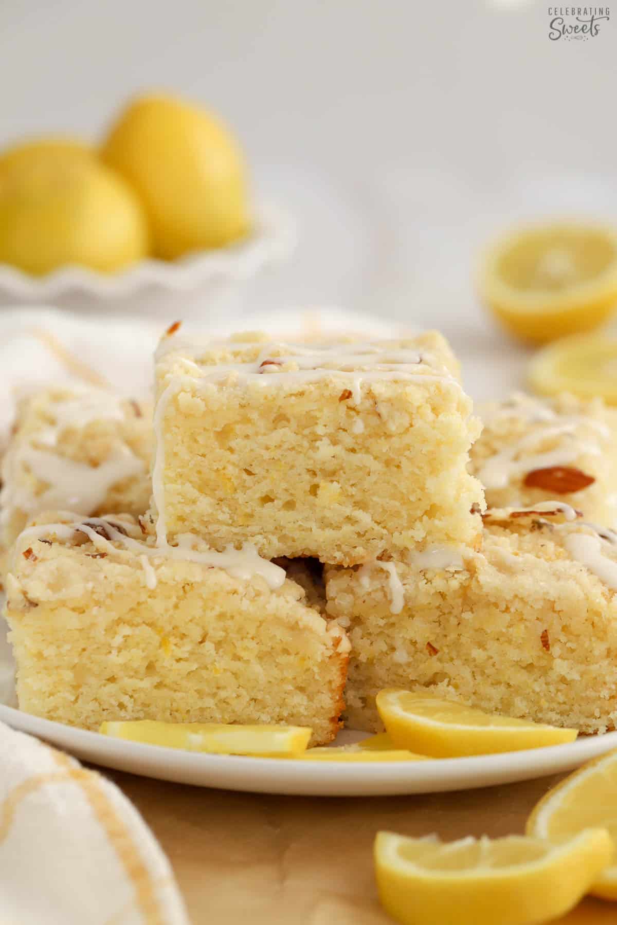 Stack of lemon cake squares on a white plate.