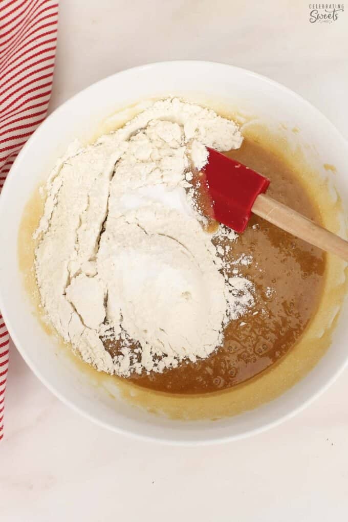 Flour, melted butter, and sugar in a white bowl.