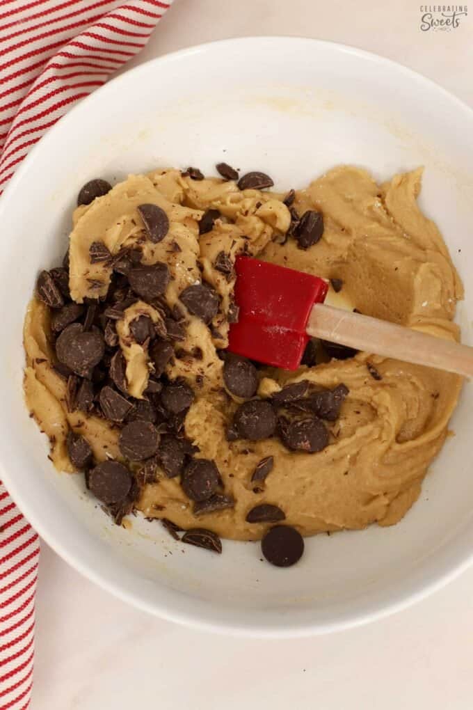 Cookie dough and chocolate chips in a white bowl.