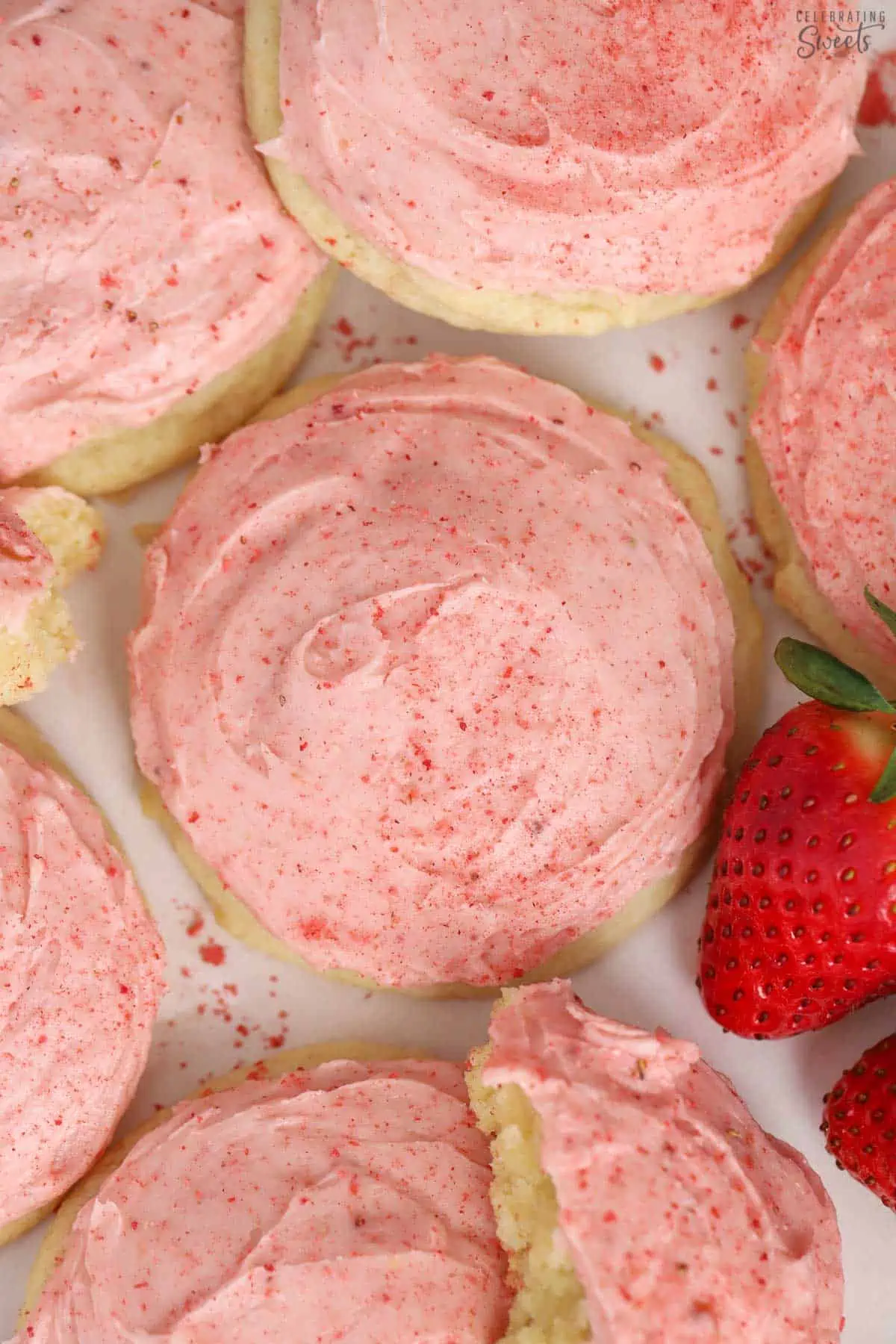 Sugar cookies topped with pink strawberry frosting.