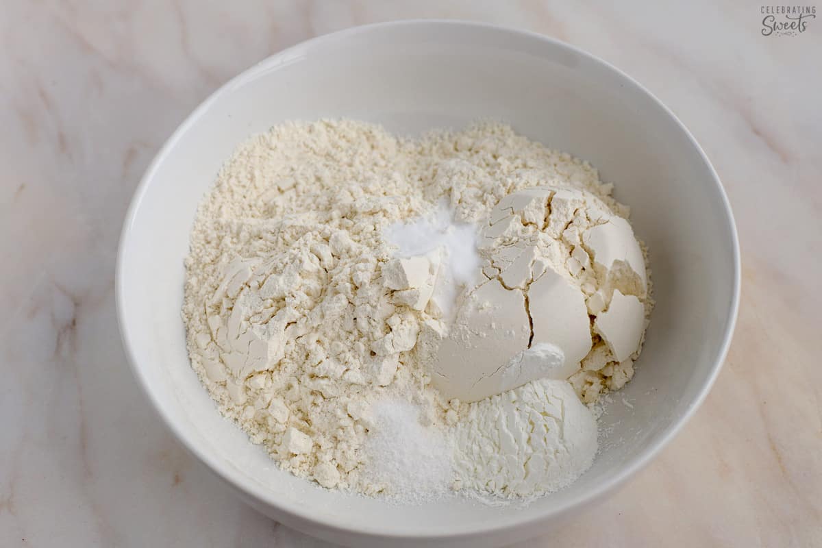 Flour, salt, and baking soda in a white bowl.