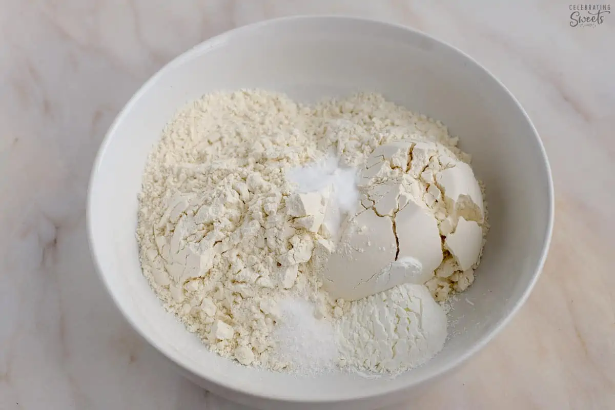 Flour, salt, and baking soda in a white bowl.