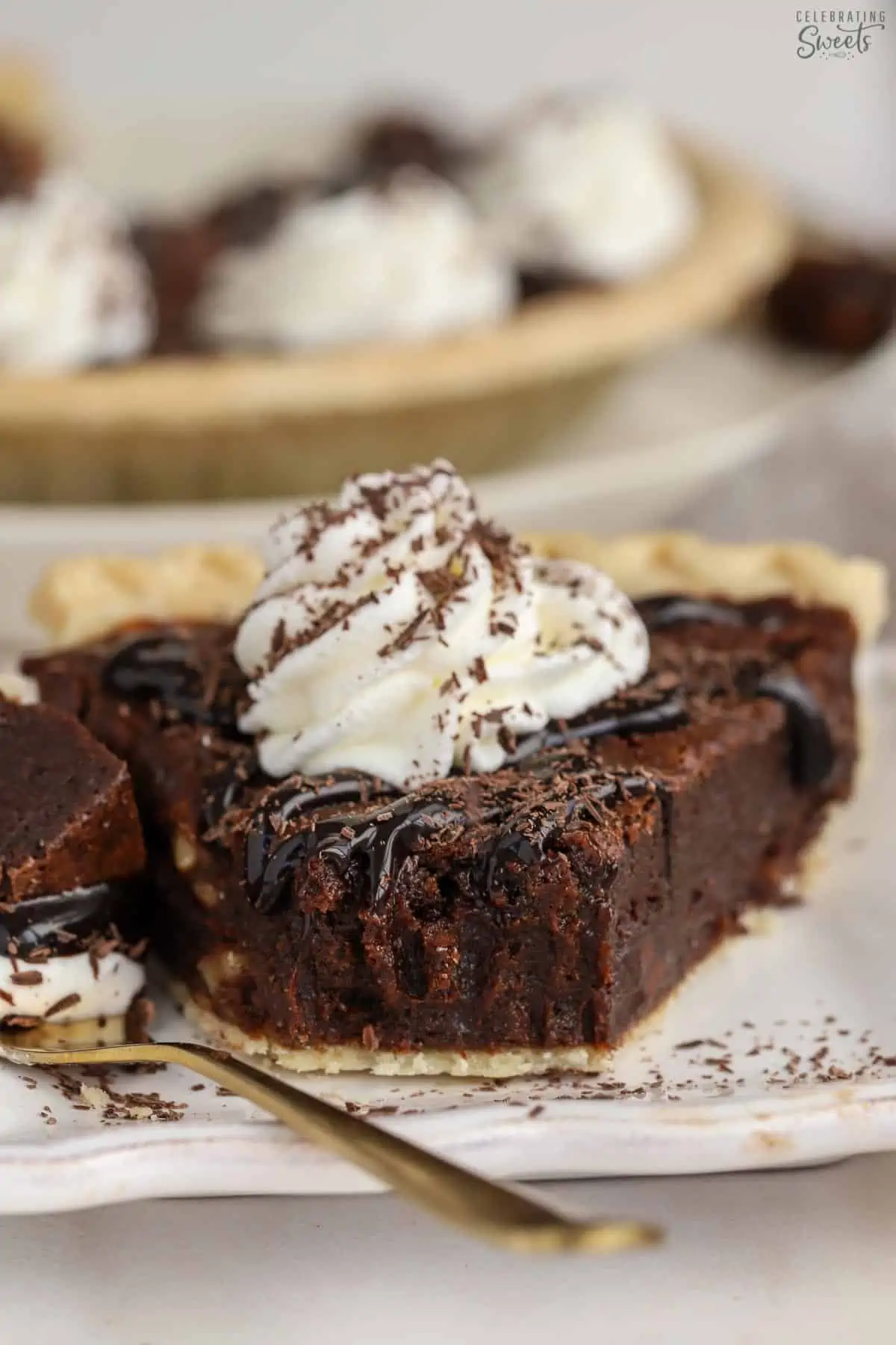 Slice of brownie pie topped with whipped cream and chocolate sauce.