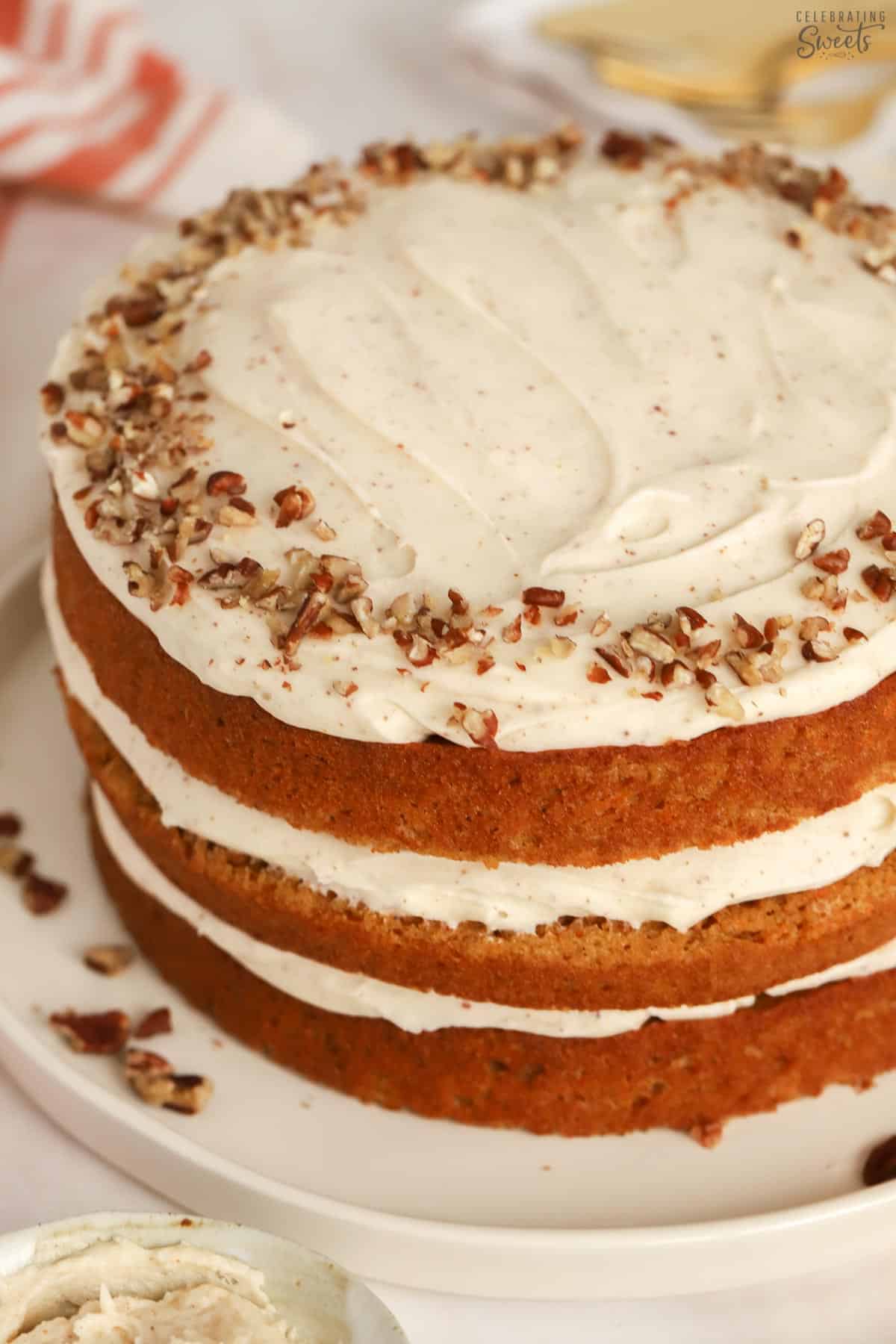 Three layer carrot cake on a white plate.