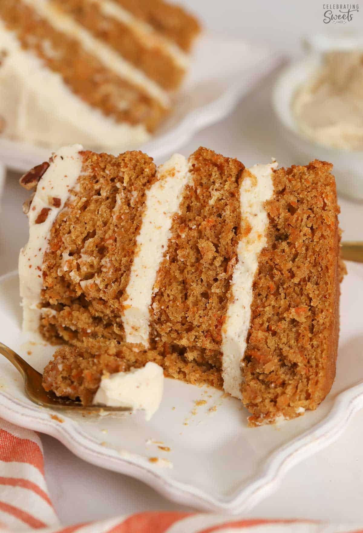 Slice of  three layered carrot cake on a white plate.