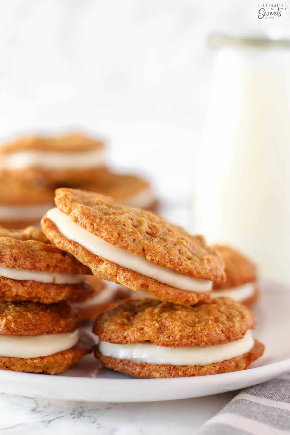 Stack of carrot cake cookies on a white plate.