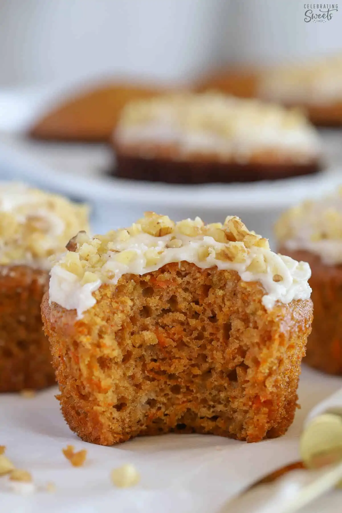 Carrot muffin with a large bite taken out of it.