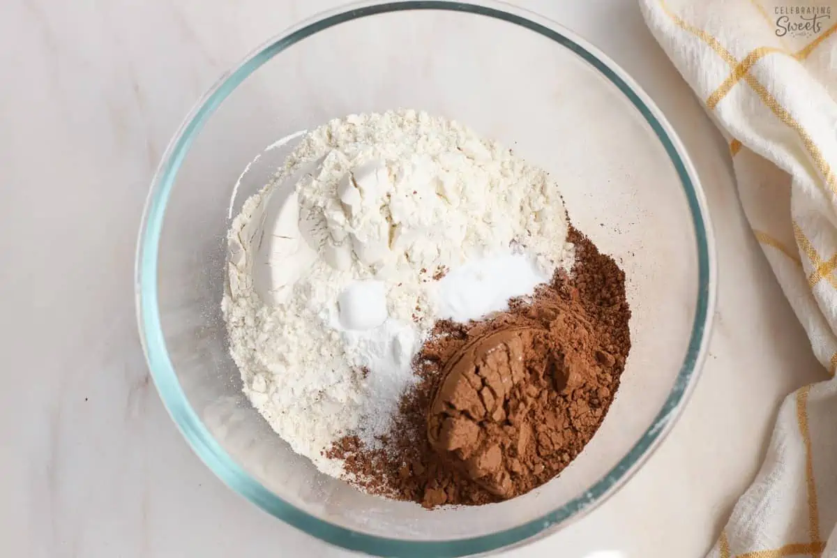 Cocoa powder, flour, baking soda, salt in a glass bowl.