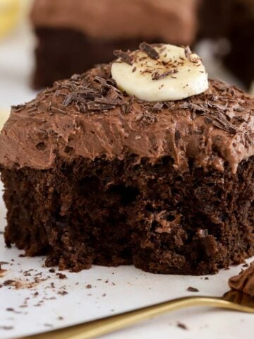 Slice of chocolate banana cake topped with chocolate shavings and sliced banana