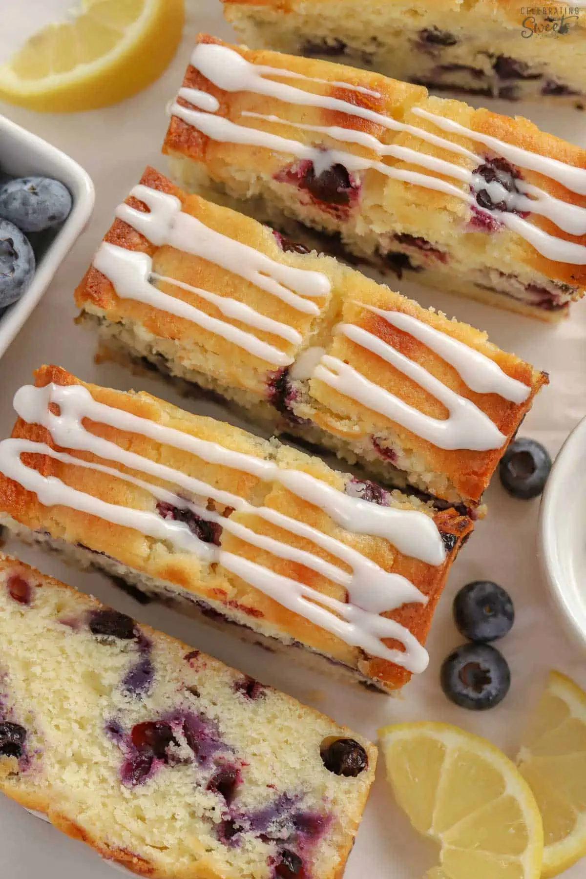 Slices of lemon blueberry bread with white icing drizzled over the top.