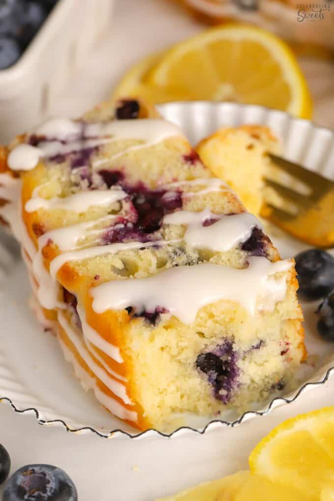 Thick slice of lemon blueberry bread on a white plate.