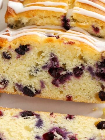 Slices of lemon blueberry bread with white icing drizzled over the top.