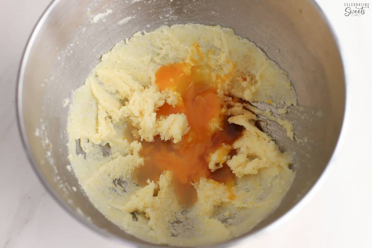Sugar, butter, eggs, and vanilla in a mixing bowl.