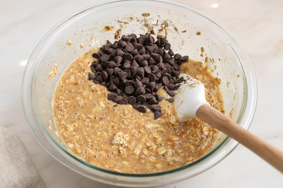 Chocolate chips and oatmeal in a glass bowl.