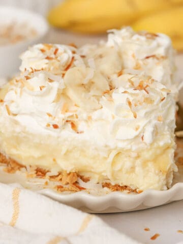 Slice of banana coconut cream pie on a white plate.